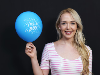 Caucasian woman standing in front of a dark chalkboard. The chal