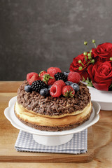 Cheesecake with chocolate topping decorated with summer fruits