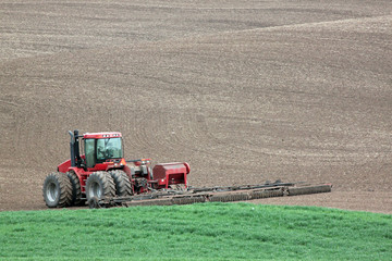 Hard at Work: Red Tractor Plowing in the Palouse