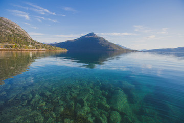 Beautiful vibrant summer norwegian landscape with coast of fjord with a blue sky, blue clear water, norway, norge