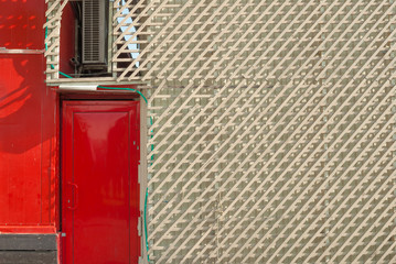 lattice of wooden planks with a red door