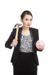Asian business woman with pig coin bank and hammer