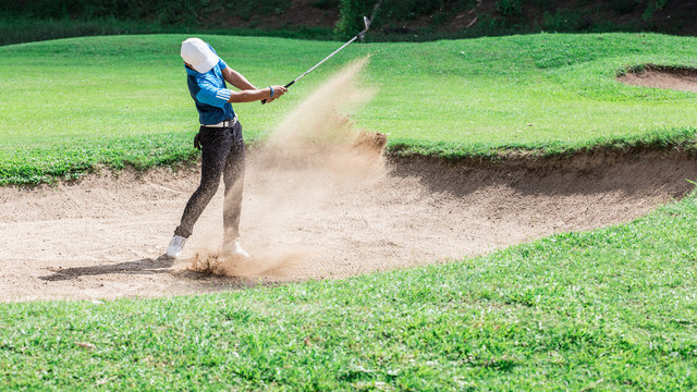 Yong asian golfer explosion sand.