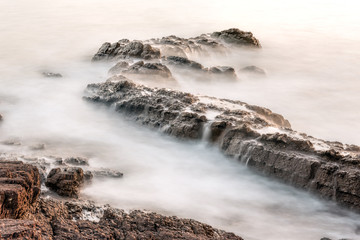 Foggy waters surrounding by rocks