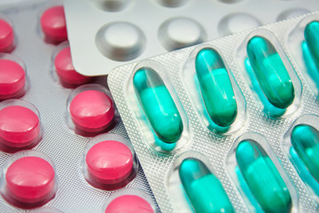 Capsules and pills packed in blisters isolated on white close-up