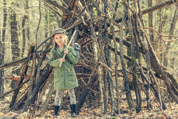 little cute girl near her hut in the forest