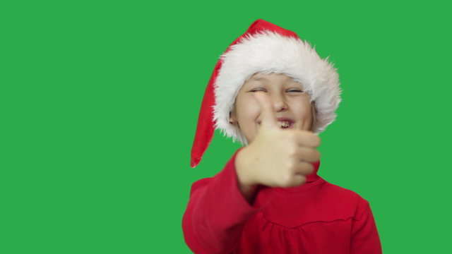 girl in hat Santa Claus showing thumb on green screen