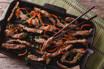Korean bulgogi beef with carrot on grill pan closeup. horizontal top view
