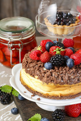 Cheesecake with chocolate topping decorated with summer fruits