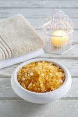 Bowl of yellow sea salt, two soft towels and vintage birdcage wi