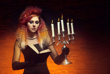 Young and beautiful witch making a witchcraft in dungeon. Hallow