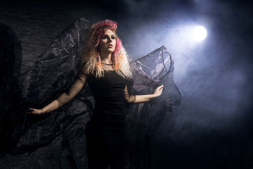 Witch in a blowing textile over the Halloween  background.