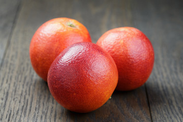 whole red sicilian oranges on wood table