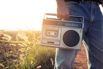 Man hand holding vintage radio on nature background