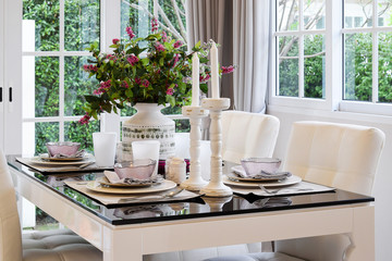 dining table and comfortable chairs in vintage style with elegant table setting