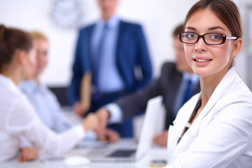 Business people shaking hands, finishing up a meeting, in office
