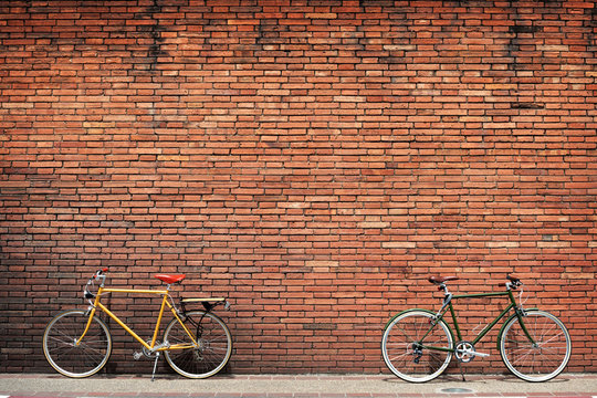 Retro bicycle on roadside with vintage brick wall background - Powered by Adobe