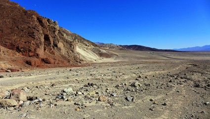 Rote Felsen und eine ferne Straße im Tal des Todes