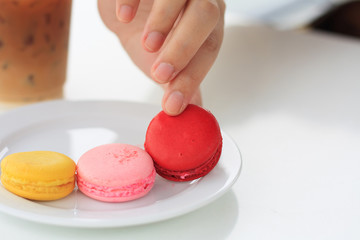 woman's hand picked a macaron