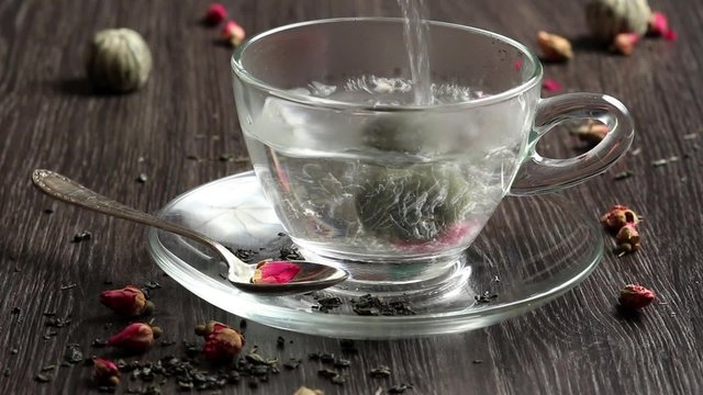 Green tea ball dropdown into glass cup