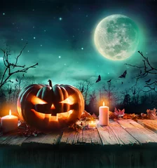 Foto op Plexiglas Halloween Pumpkin On Wooden Plank With Candles In A Spooky Night   © Romolo Tavani
