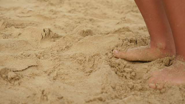 Young child destroys sand castles

