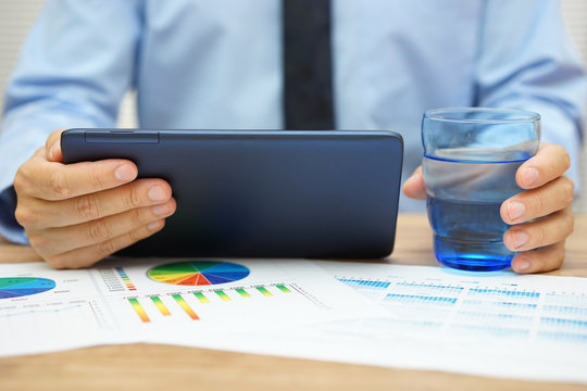 businessman it watching financial news on tablet computer and dr