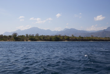 Calm sea with clear water and green coast in Bali