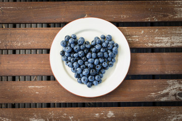 Bilberry on a plate on a wooden table