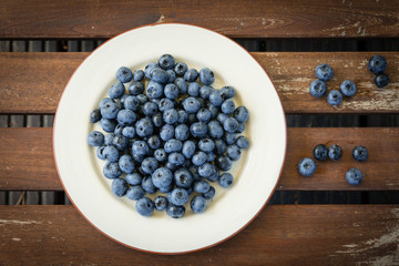 Bilberry on a plate on a wooden table
