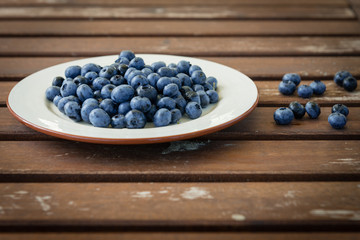 Bilberry on a plate on a wooden table