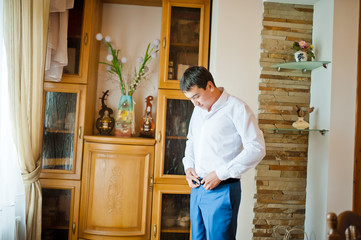 groom  gets dressed in formal wear and blue suit