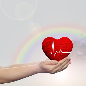 Human hand with heart and rainbow