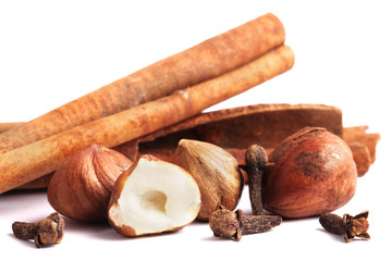 Cinnamon, clove and hazelnut isolated on white.