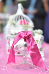 pink ribbon on a chrystal holder with candies inside on a pink table