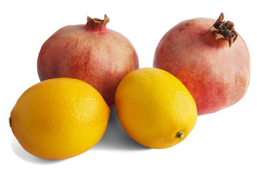 Pomegranate and lemon isolated on white.