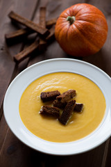 Close-up of pumpkin cream-soup with croutons, selective focus