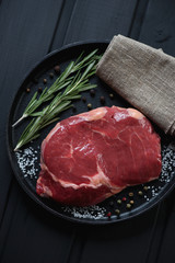 Top view of raw ribeye steak in a frying pan, close-up