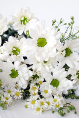 White daisy bouquet on white wood background