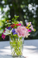 Bouquet flowers in glass vase on outdoor and bokeh background