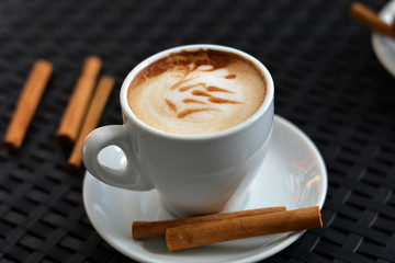 Cup of delicious foamy cappuccino on the black background