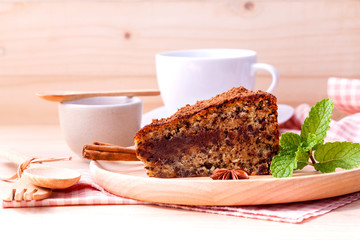 Homemade dark chocolate cake with cup of coffee on wooden backgr
