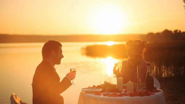 Couple sharing romantic sunset dinner on the beach