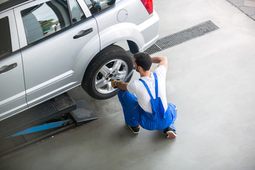 Mechanic removing a tire from a car