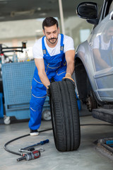 Fototapeta na wymiar mechanic repair and pushing a black tyre