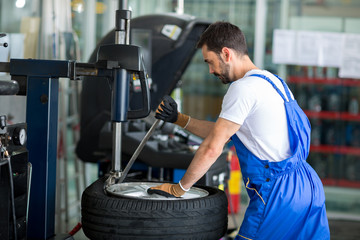mechanic replace tires on wheels - obrazy, fototapety, plakaty