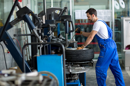 repairman balancing  car wheel on balancer