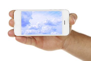 Hand holding mobile smart phone with sky in screen. Cloud computing concept