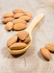 Almonds on a wooden spoon.