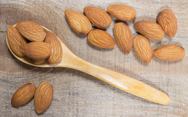 Almonds on a wooden spoon.
